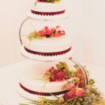 Classic Ivory cake with brown ribbon, garnished with real flowers.